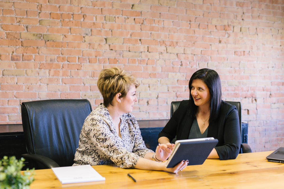 Two business women talking at table